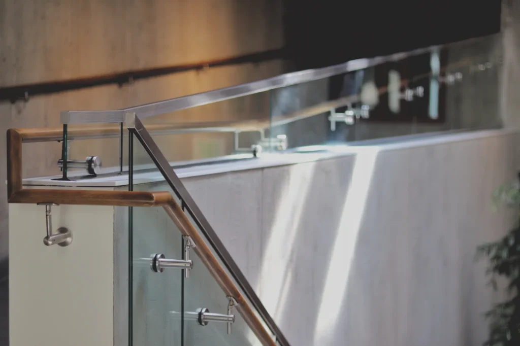 Glass railing with a wood handrail mounted on stainless standoffs