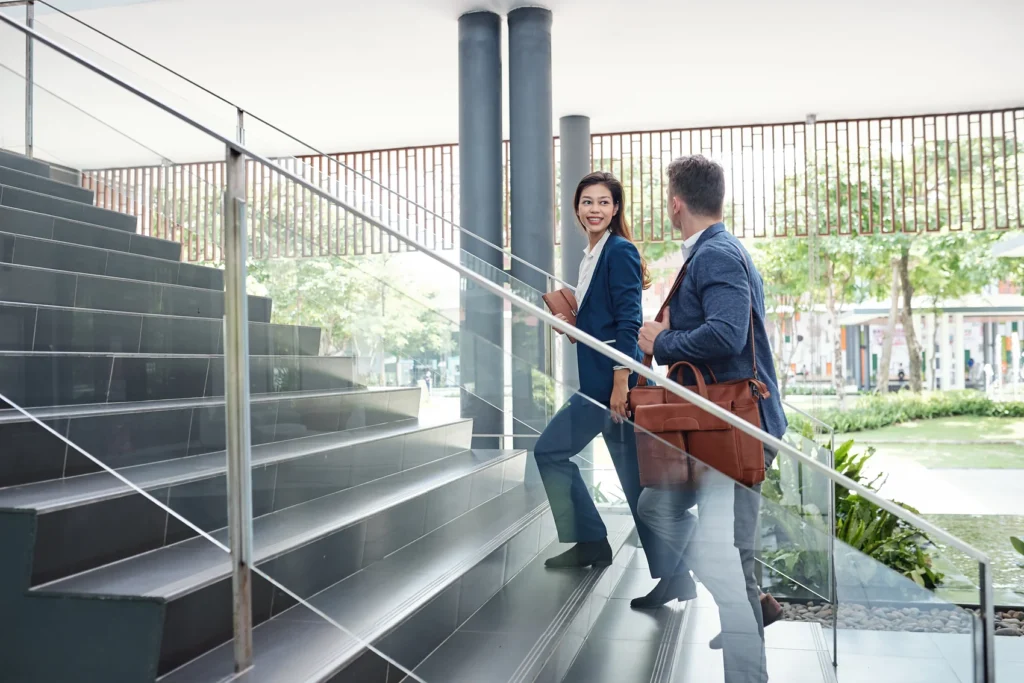 People walking up a staircase with a glass railing that keeps sightlines open